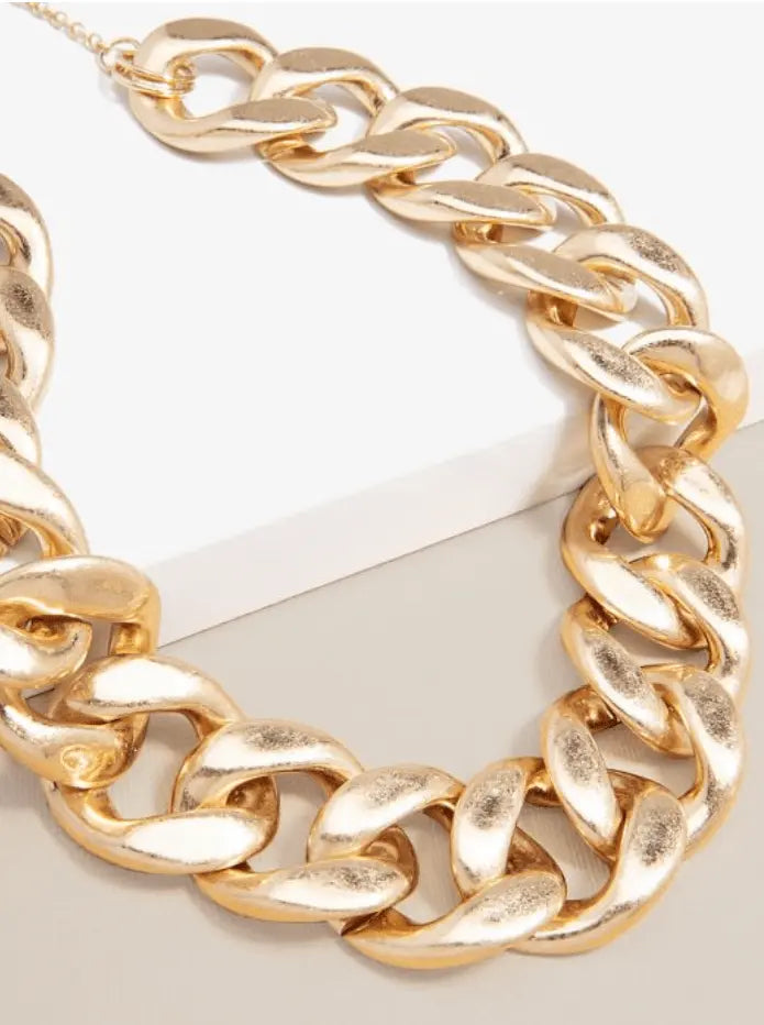 Charlie Gold Chain Necklace rests on a white surface a striking women's statement necklace