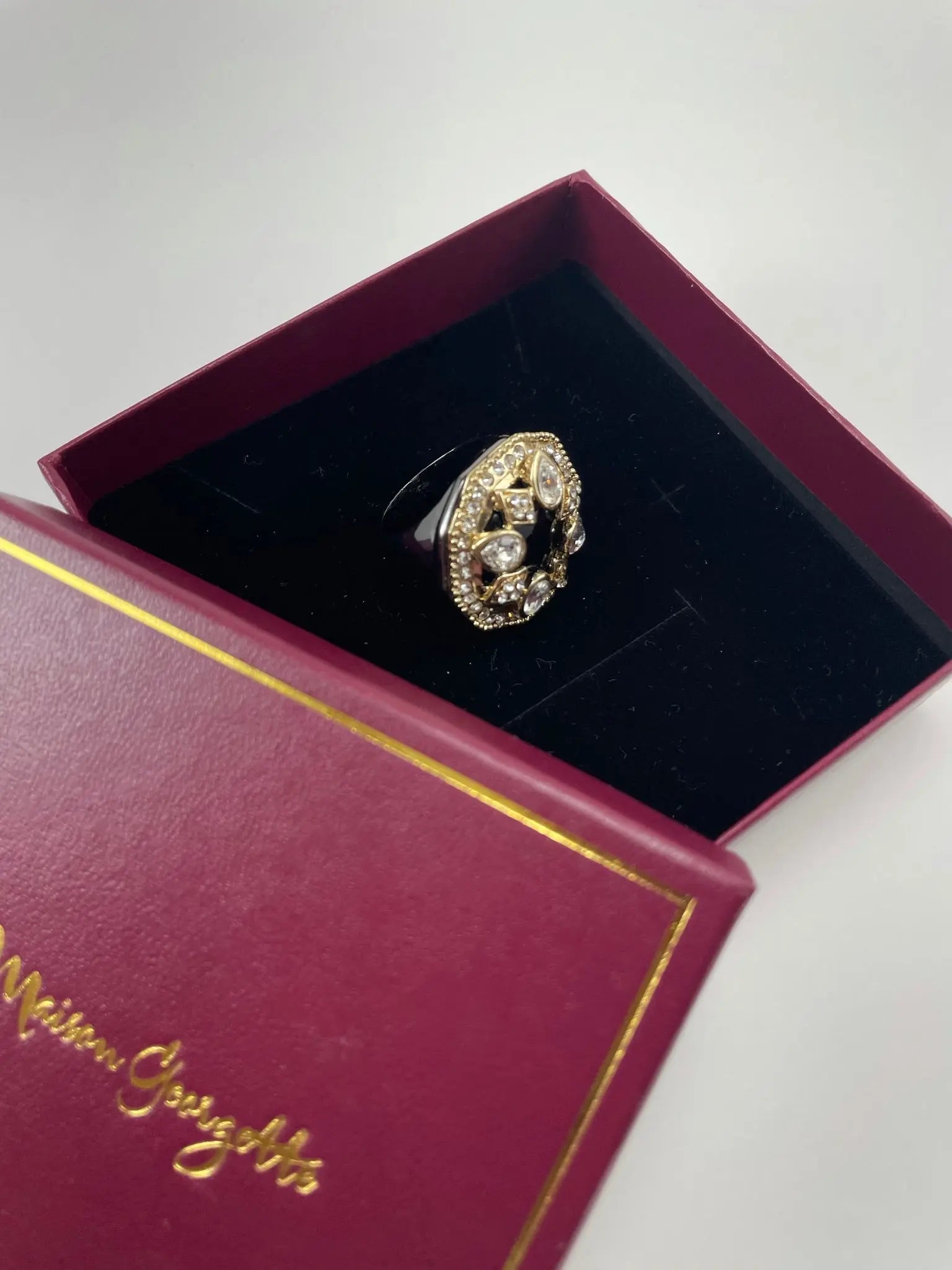 A luxurious women's rings ebony cocktail ring featuring a gold and black diamond presented in a red box