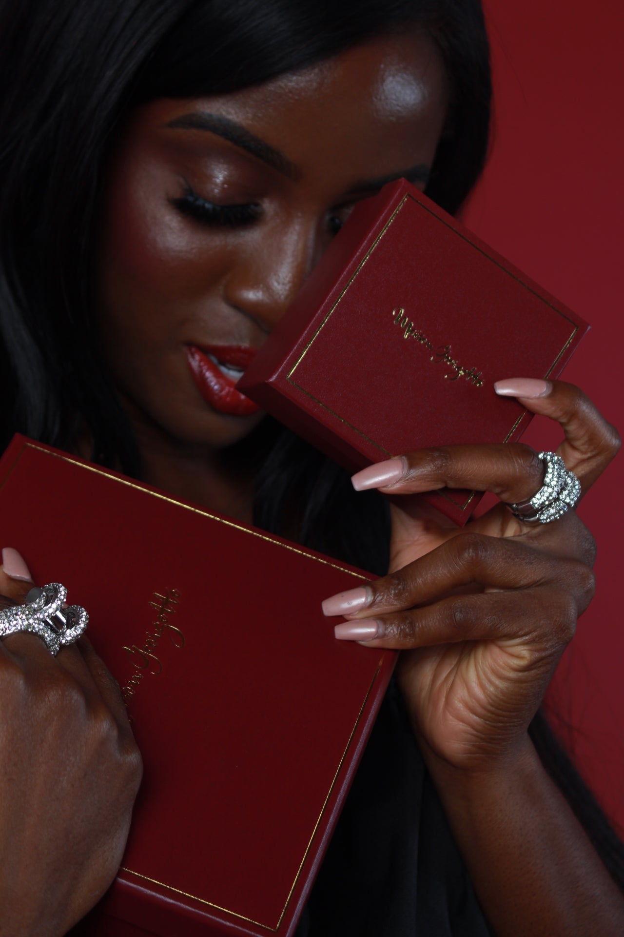 A woman showcases a red box with a ring, symbolizing the charm of Maison Georgette's affordable luxury jewelry collection