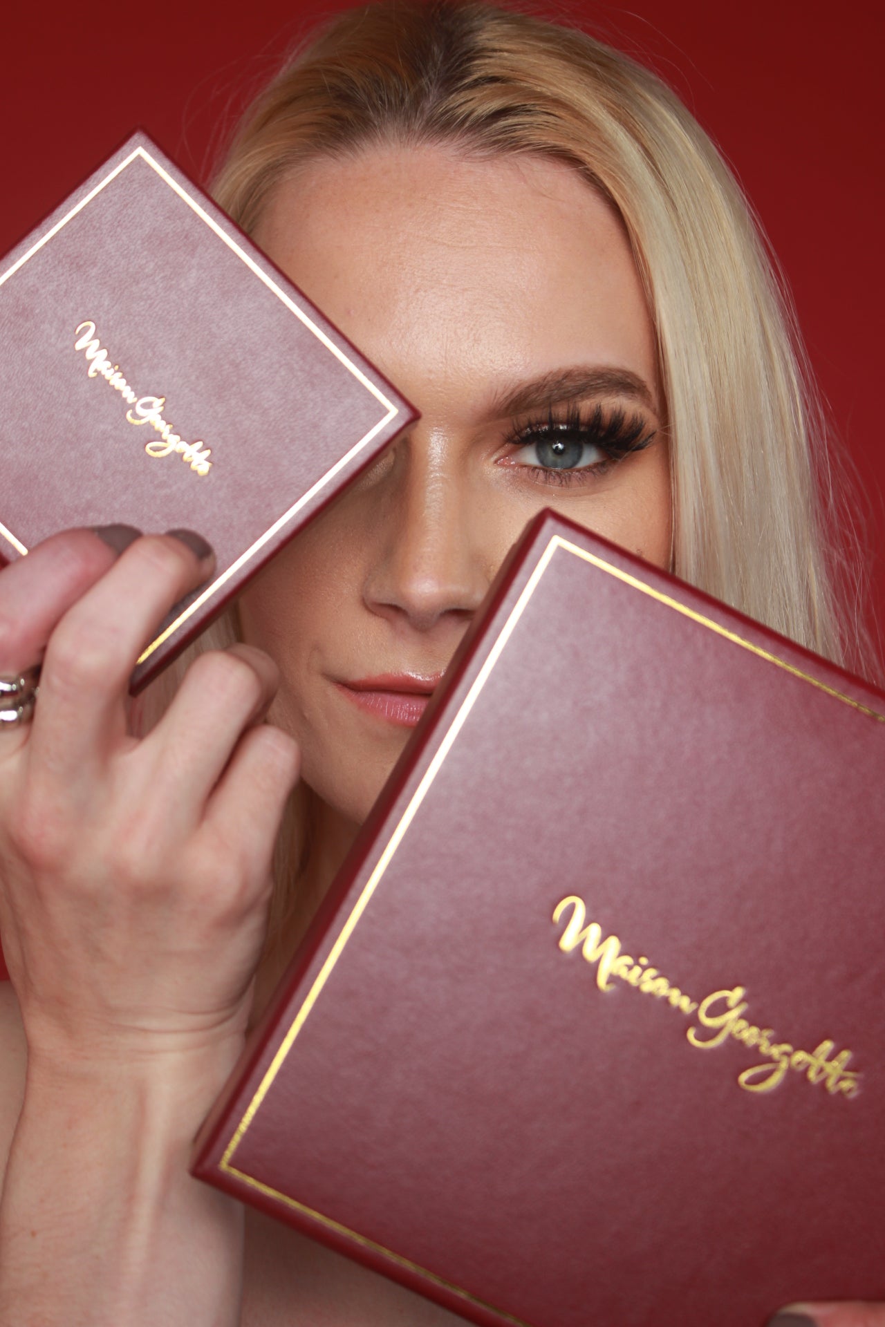 A woman showcases two makeup boxes, paired with Maison Georgette's affordable luxury jewelry
