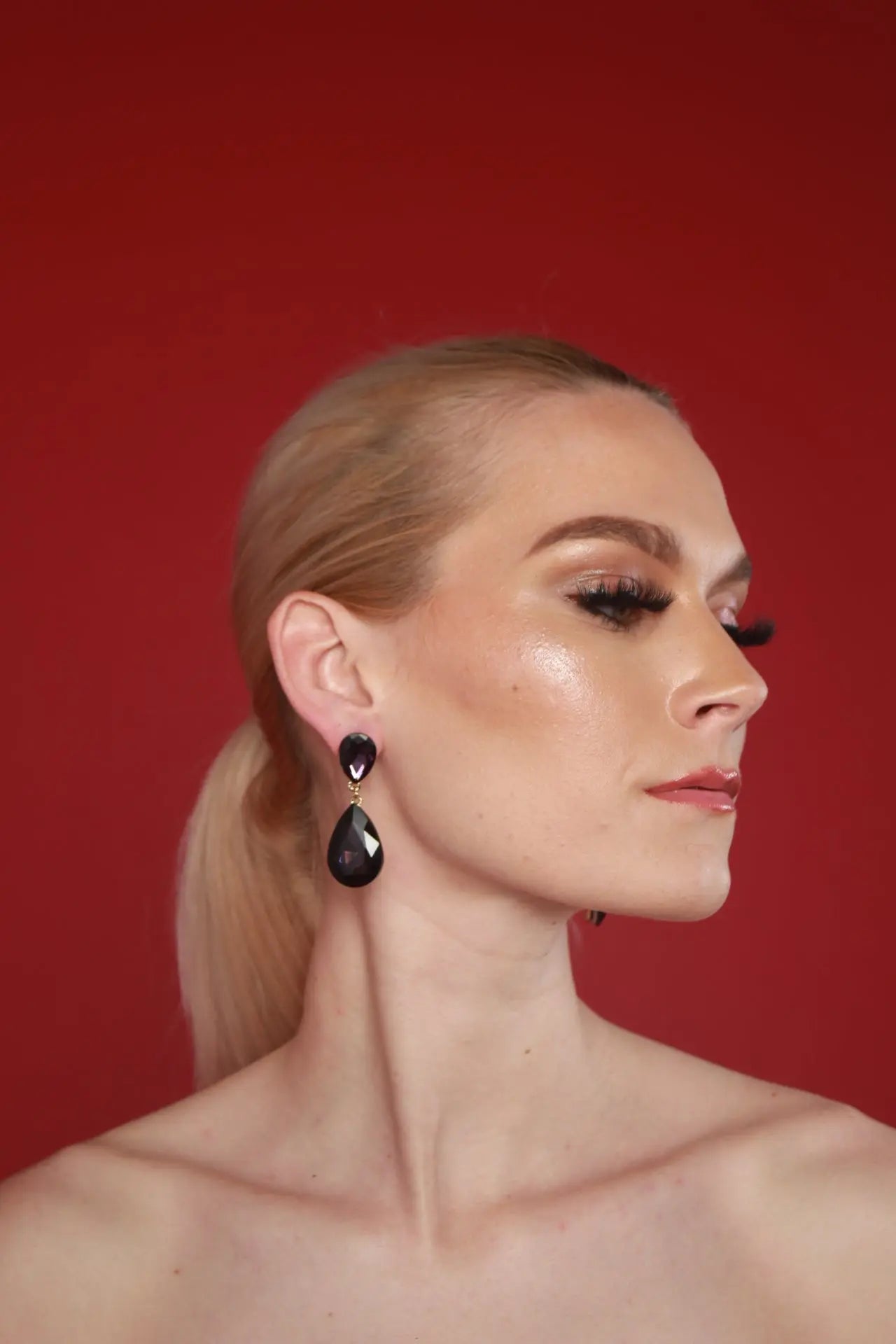 A woman features black Lori Teardrop Earrings, showcasing a luxury women's earrings