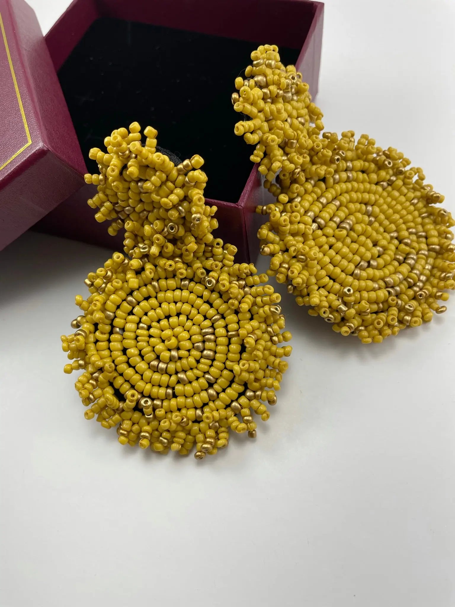 A box containing luxury women's earrings yellow beaded earrings, featuring design of Lydia Beaded Disc Earrings