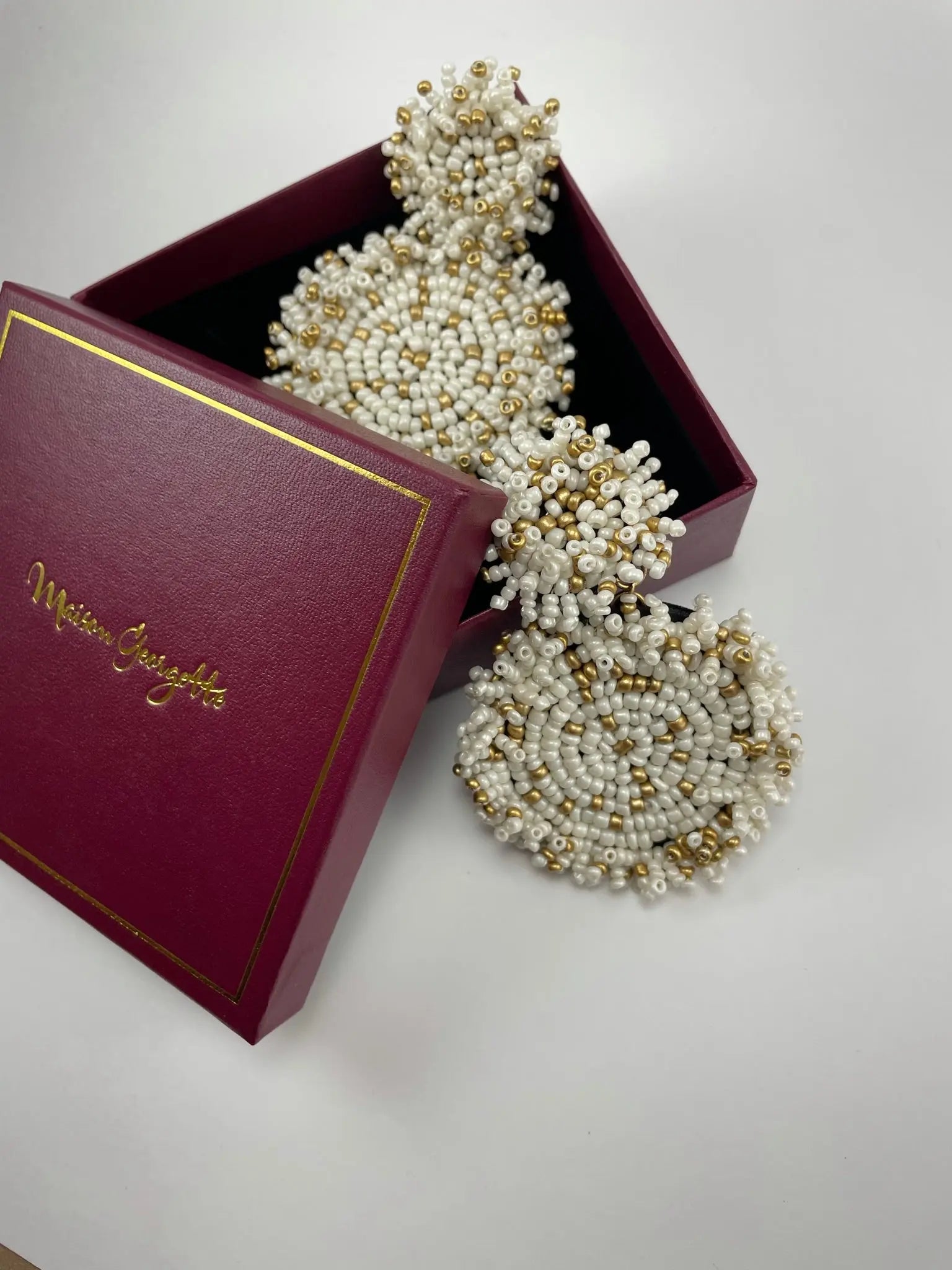 A luxury women's earring pair of Lydia Beaded Disc Earrings displayed in a box.