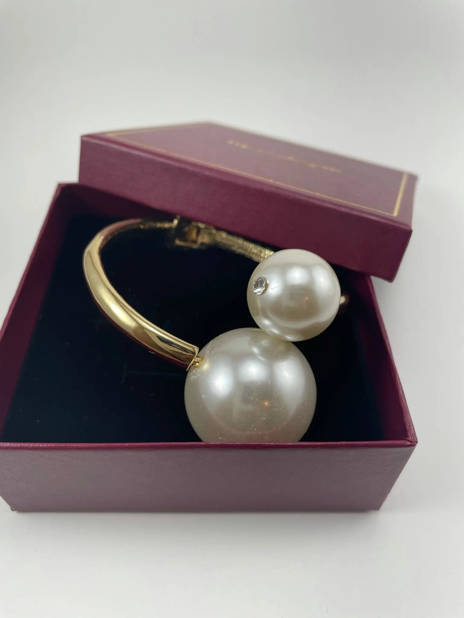 A pair of Lydia Pearl and gold cuff bracelets displayed in a box, showcasing luxury women's necklace.
