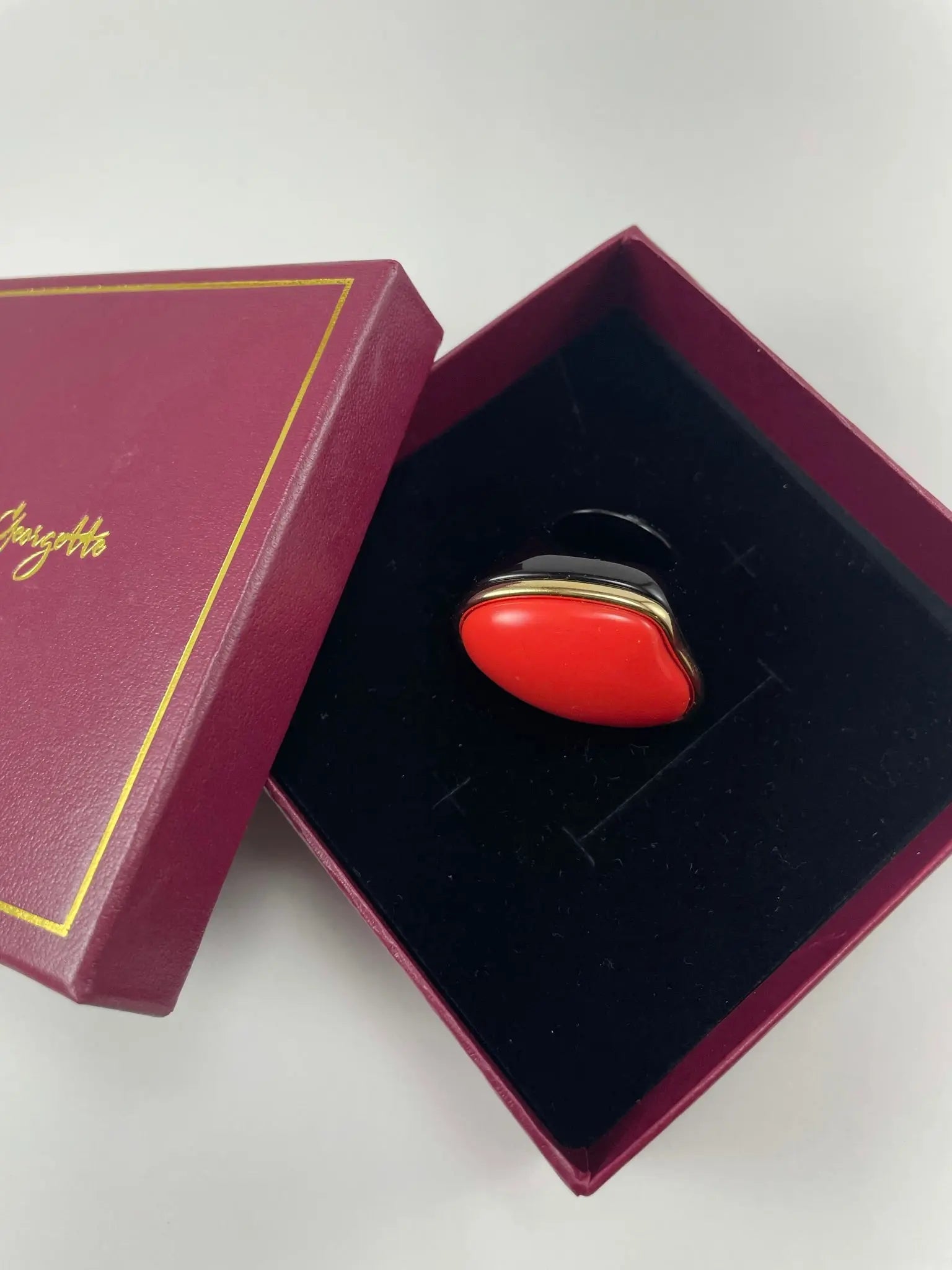 A red Sierra Stone ring elegantly presented in a box featuring and symbolizing luxury women's rings