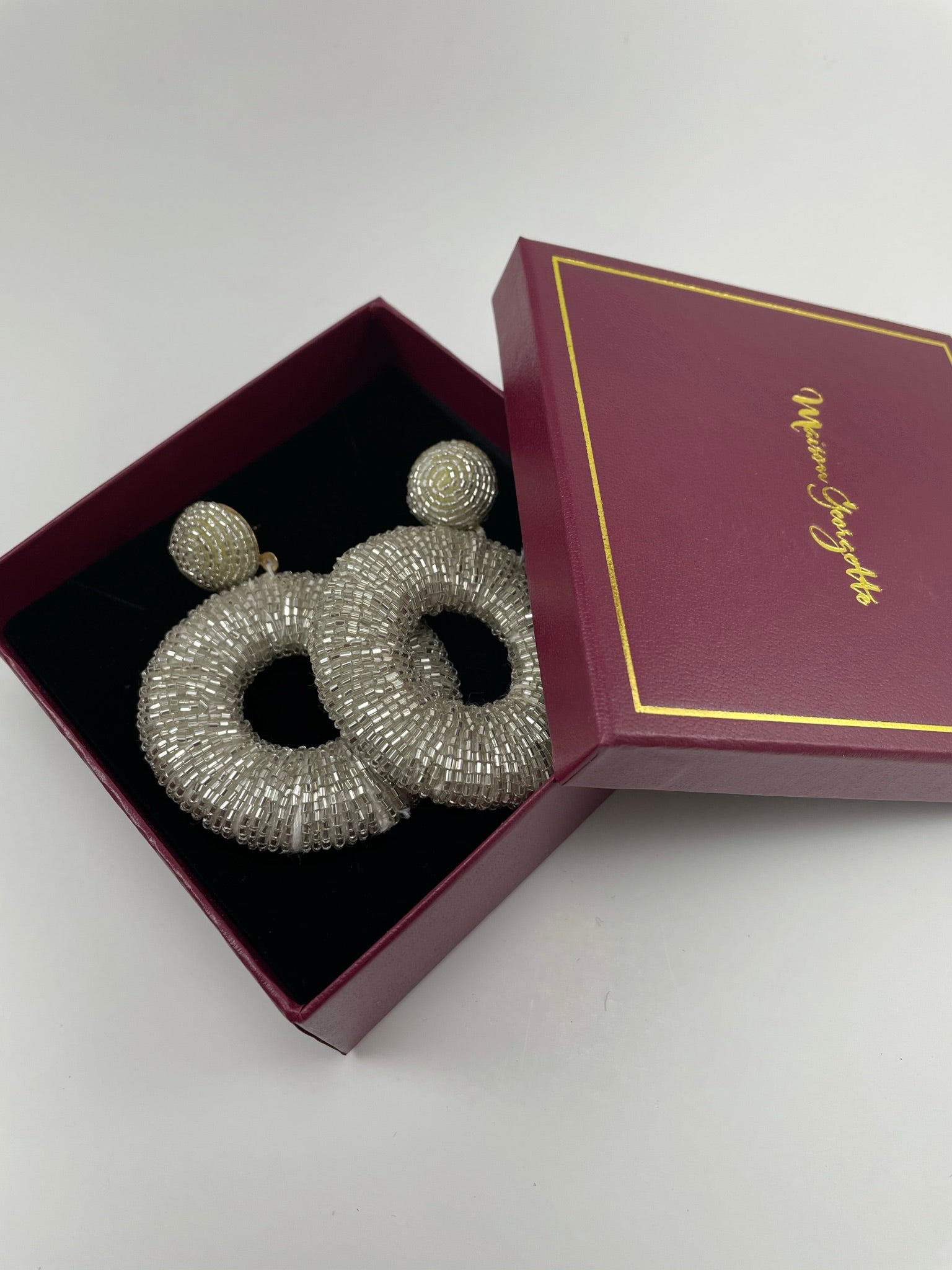 A pair of silver hoop earrings in a stylish box emphasizing the luxury women's earrings collection