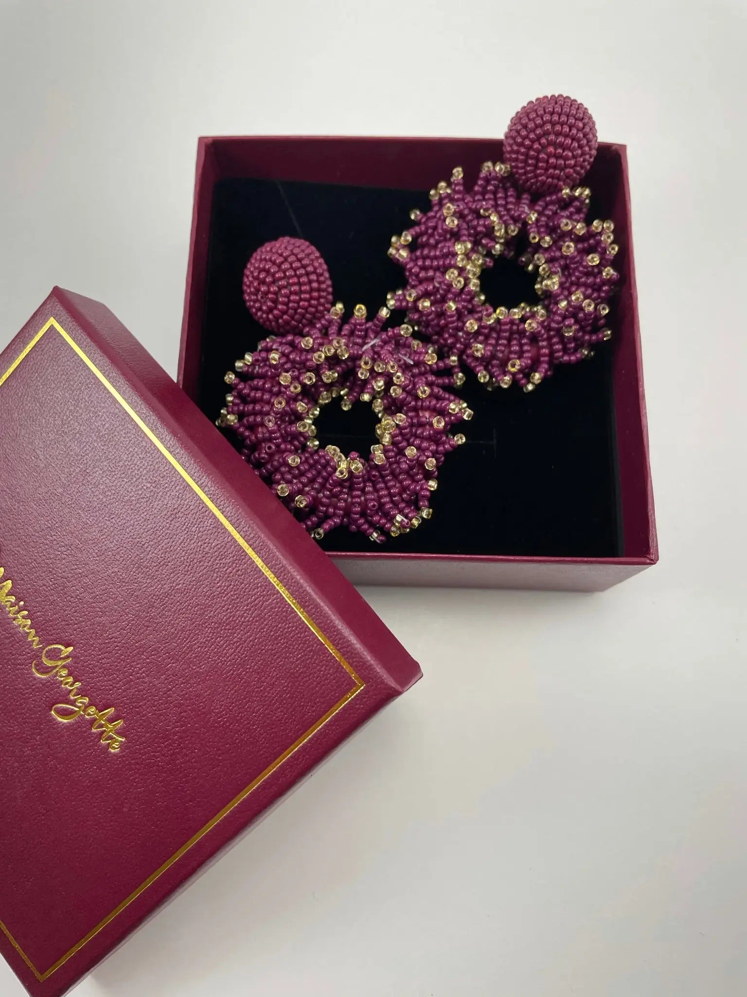 Elegant purple Jerri Drop Hoop Earrings nestled in a box, representing affordable luxury jewelry
